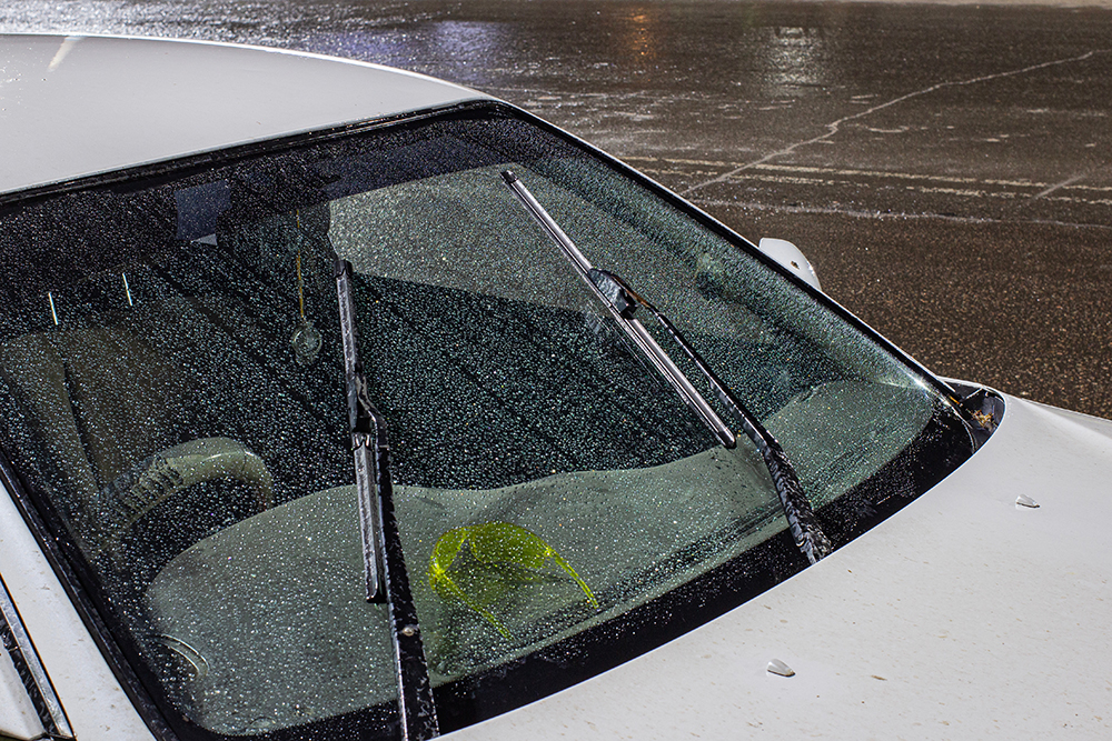 view from the inside of a working car at night on an illuminated